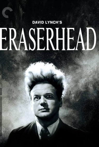 Man with distinctive tall, frizzy hair and a serious expression in a dark, atmospheric setting.